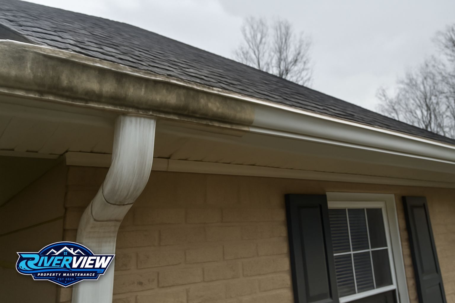 Technician clearing compacted debris and pine pollen from gutters on a Grayson, GA home