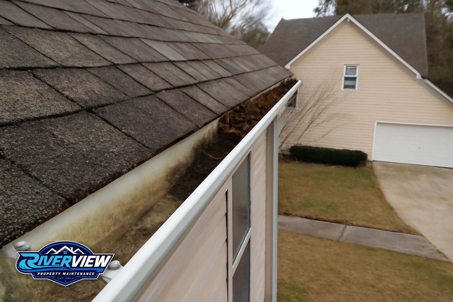 Technician flushing downspouts on a two-story Lawrenceville home in 30045