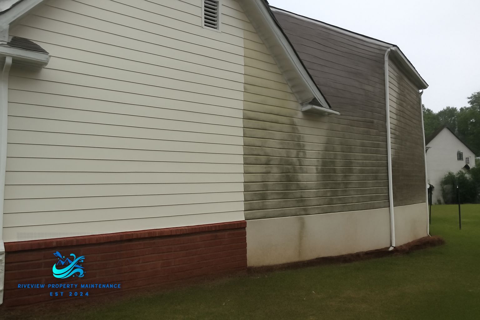 Riverview Property Maintenance technician soft washing the siding and trim on a two-story home in Gwinnett County Georgia