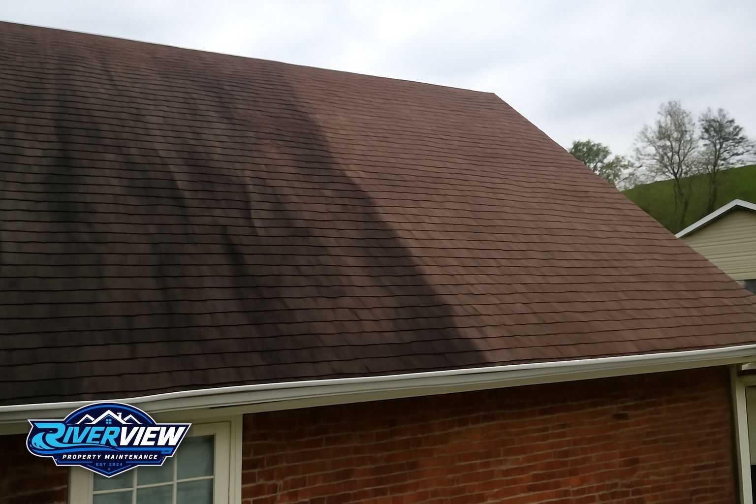 Riverview Property Maintenance technician applying soft wash solution to a Gwinnett County roof
