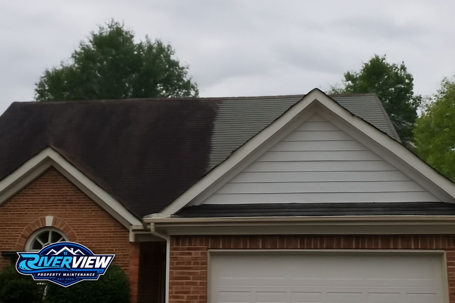 Technician applying low-pressure soft wash solution to streaked shingles on Georgia home