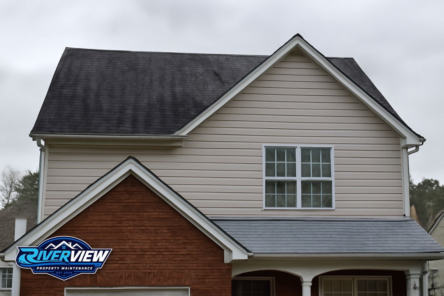 Dark algae streaks running down asphalt shingles on a Mulberry, GA home before soft washing