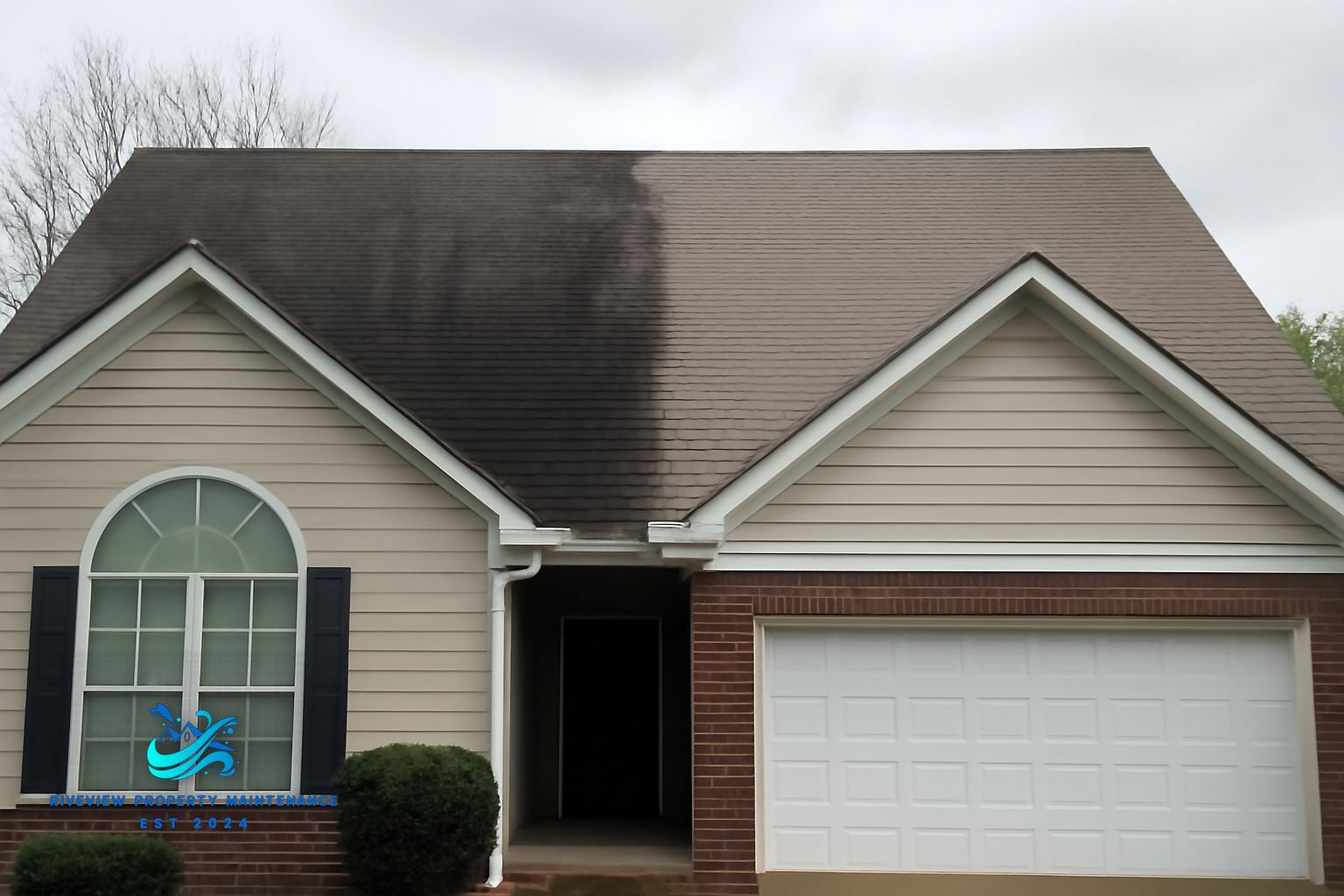 Soft washing a residential roof with dark algae streaks in Winder, Georgia